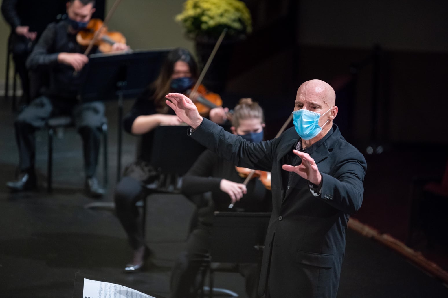 Maestro Mark Russell Smith conducting the QCSO wearing a mask at Davenport's Adler Theatre.